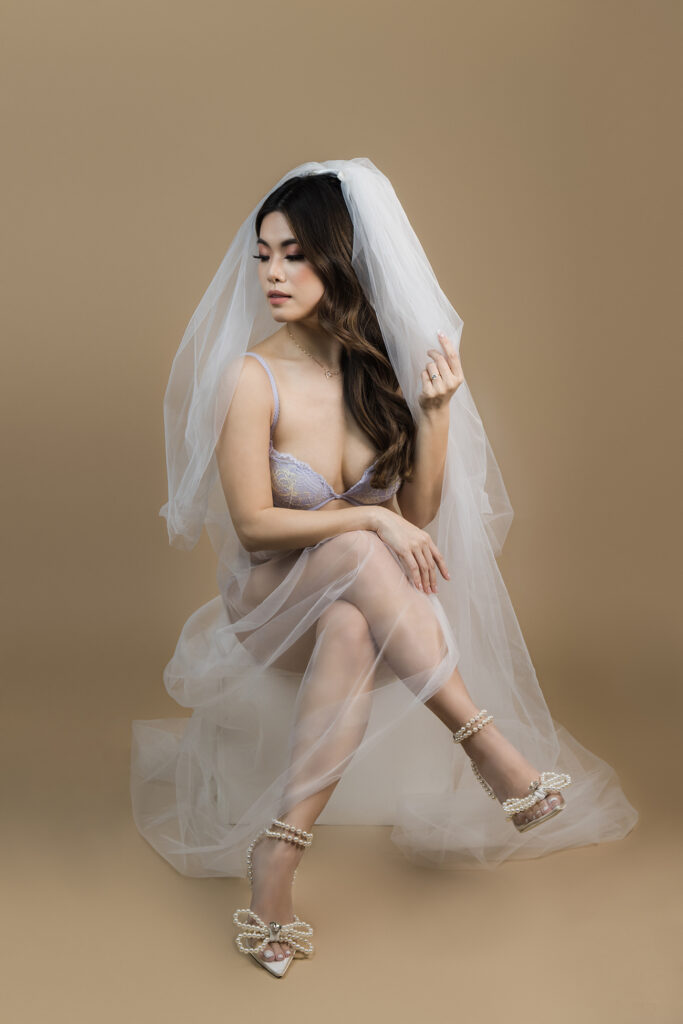 Beautiful bridal boudoir photo of bride in elegant lingerie, posed in natural light and studio light.
