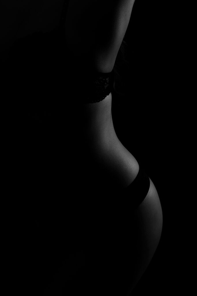 Beautiful bridal boudoir photo of bride in elegant lingerie, posed in natural light and studio light.